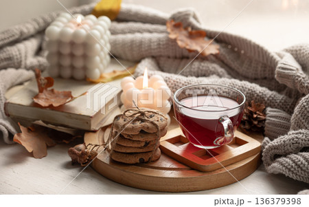 Autumn still life with a cup of tea, cookies and a knitted item. Autumn still life with a cup of tea, cookies and a knitted item. 136379398