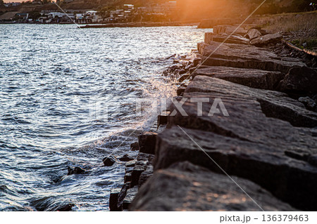 Beautiful sea at sunset near the rocky shore Beautiful sea at sunset near the rocky shore 136379463