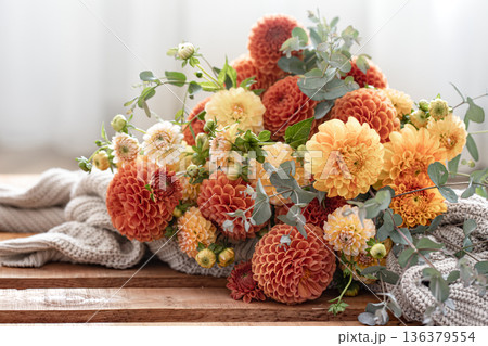 A bouquet of yellow and orange chrysanthemums on a blurred background. A bouquet of yellow and orange chrysanthemums on a blurred background. 136379554