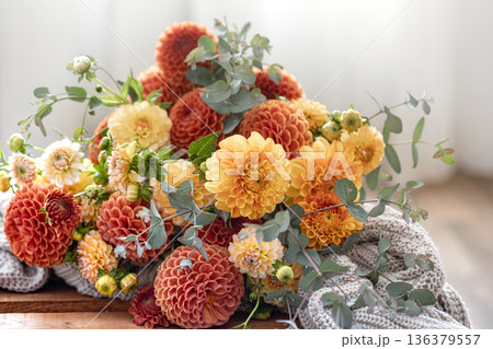 A bouquet of yellow and orange chrysanthemums on a blurred background. 136379557