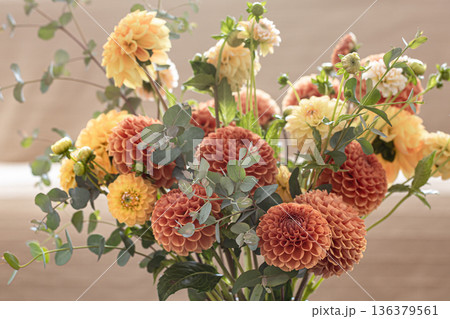 A bouquet of yellow and orange chrysanthemums on a blurred background. 136379561