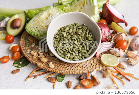 Close-up, a bowl of pumpkin seeds and other healthy foods on the kitchen table. 136379656