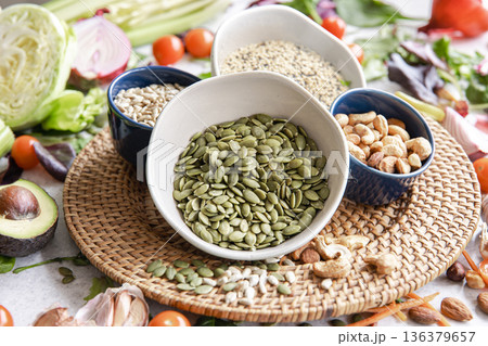 Close-up, a bowl of pumpkin seeds and other healthy foods on the kitchen table. 136379657