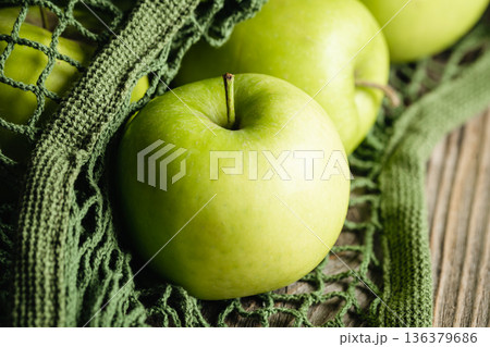 Close-up, green apples in a mesh shopping bag. Close-up, green apples in a mesh shopping bag. 136379686
