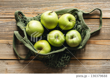 Close-up, green apples in a mesh shopping bag, top view. Close-up, green apples in a mesh shopping bag, top view. 136379688