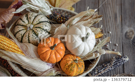 Close-up of pumpkin, corn and autumn leaves on a wooden background. 136379712