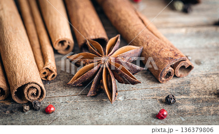 Composition with star anise and cinnamon sticks on a wooden background. Composition with star anise and cinnamon sticks on a wooden background. 136379806