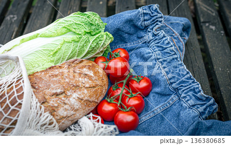 Vegetables and bread in a shopping bag, picnic concept. Vegetables and bread in a shopping bag, picnic concept. 136380685