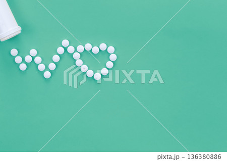 Scattered heart shaped pills on green background, flat lay. Scattered heart shaped pills on green background, flat lay. 136380886
