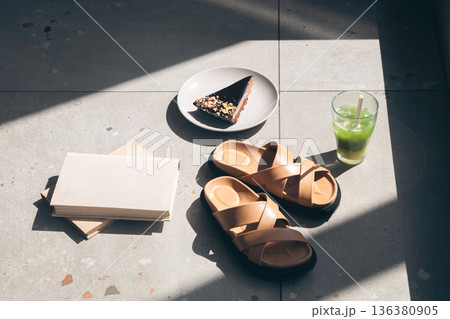 Slippers, lemonade, piece of cake and books on tiles by the pool. Slippers, lemonade, piece of cake and books on tiles by the pool. 136380905
