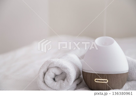 Spa composition with aroma diffuser and towel on a blurred background. 136380961