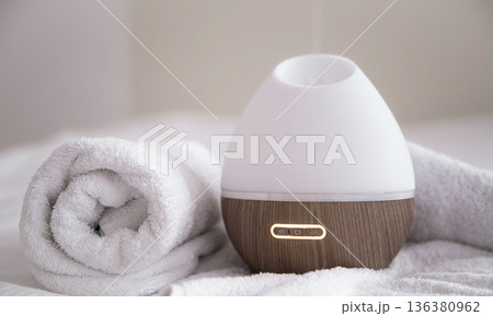 Spa composition with aroma diffuser and towel on a blurred background. 136380962