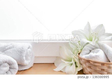 Spa composition with lily flowers and towels in a basket. 136380995