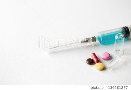 Syringe and pills on a white background isolated, close-up. Syringe and pills on a white background isolated, close-up. 136381277