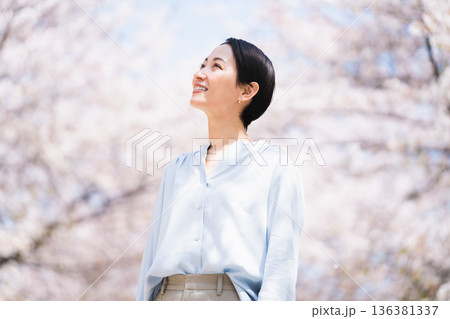 桜を見上げる若い女性　ライフスタイルイメージ 136381337
