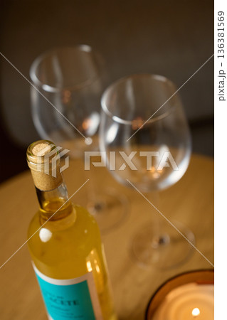 Bottle of white wine with glasses on table for romantic evening Bottle of white wine with glasses on table for romantic evening 136381569