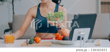 Fit young Asian women in activewear sitting on yoga mat and eating fresh vegetable salad after workout, representing clean eating, fitness lifestyle, wellness routine and health balance. Fit young Asian women in activewear sitting on yoga mat and eating fresh vegetable salad after workout, representing clean eating, fitness lifestyle, wellness routine and health balance. 136381651