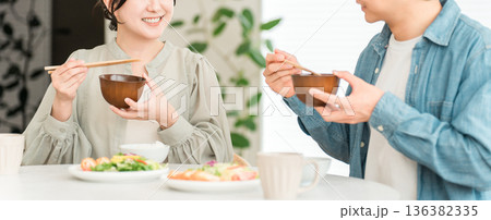 マイホームのダイニングテーブルで食事をする若いアジア人夫婦,カップル マイホームのダイニングテーブルで食事をする若いアジア人夫婦,カップル 136382335