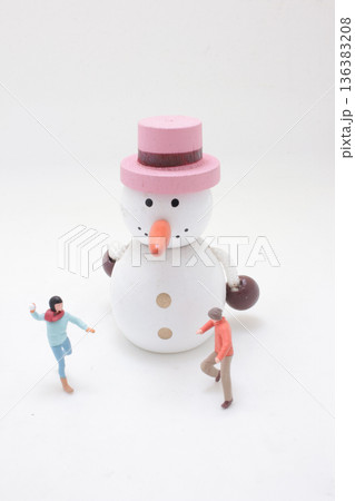 Miniature people play around large wooden snowman figure Miniature people play around large wooden snowman figure 136383208