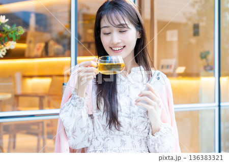 カフェのテラス席でスマホを見る女性 カフェのテラス席でスマホを見る女性 136383321