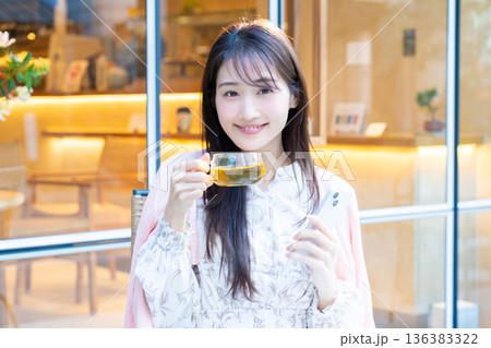 カフェのテラス席でスマホを見る女性 カフェのテラス席でスマホを見る女性 136383322