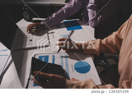 Above table with finance papers, graphs and big data during teamwork meeting with accounting or marketing team discussing budget, strategy or growth development. Closeup of SEO team doing research 136385104