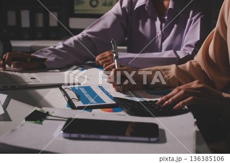 Above table with finance papers, graphs and big data during teamwork meeting with accounting or marketing team discussing budget, strategy or growth development. Closeup of SEO team doing research 136385106