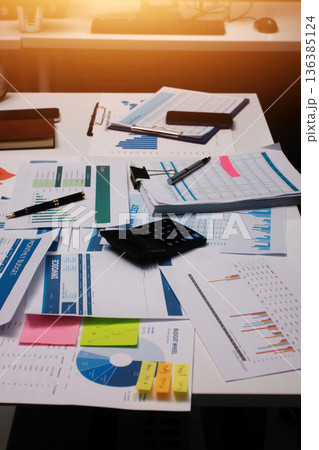 Above table with finance papers, graphs and big data during teamwork meeting with accounting or marketing team discussing budget, strategy or growth development. Closeup of SEO team doing research 136385124