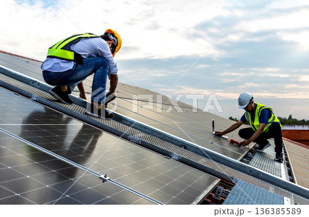 Engineer service check installation solar cell on the roof of factory.  136385589
