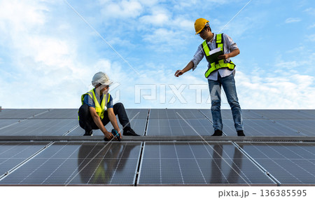 Engineer service check installation solar cell on the roof of factory.  136385595