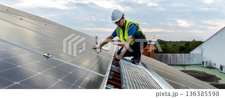 Engineer service check installation solar cell on the roof of factory.  136385598