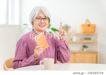 年金手帳を持つグレイヘアのシニア女性 年金手帳を持つグレイヘアのシニア女性 136385734