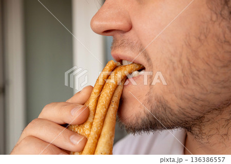 Man eating traditional pancake close up. Maslenitsa concept for Shrovetide week. Forgiving Sunday traditional holiday. Man eating traditional pancake close up. Maslenitsa concept for Shrovetide week. Forgiving Sunday traditional holiday. 136386557