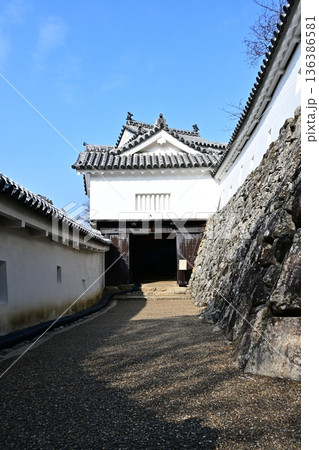 青空に映える日本の城郭:白い漆喰壁と重厚な櫓門への道 青空に映える日本の城郭:白い漆喰壁と重厚な櫓門への道 136386581