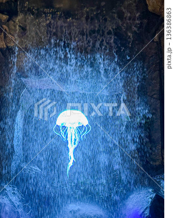 Glowing jellyfish light installation behind waterfall Glowing jellyfish light installation behind waterfall 136386863