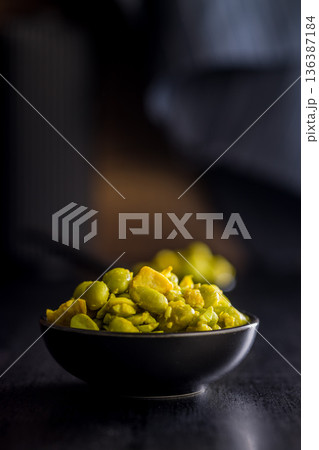 Fresh salad with edamame beans in bowl on black table. Fresh salad with edamame beans in bowl on black table. 136387184