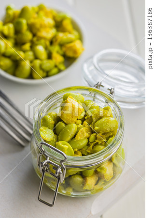 Fresh salad with edamame beans in jar on white table. 136387186