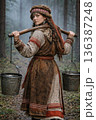 Young ethnic woman carrying water with yoke in forest 136387248