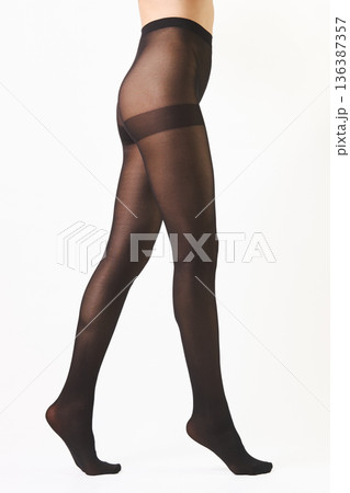Unrecognizable woman walking on tiptoes in sheer butt lifting pantyhose isolated on white background 136387357