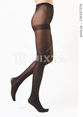 Barefoot female legs in dense black tights walking on tiptoes Barefoot female legs in dense black tights walking on tiptoes 136387359