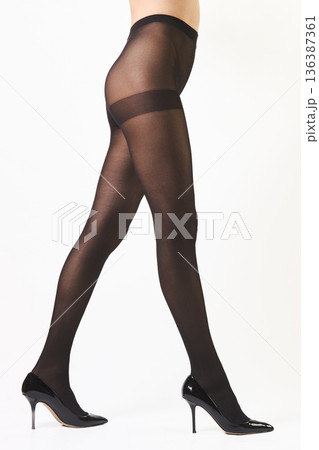 Female legs in black sculpting tights and patent leather high-heeled shoes 136387361