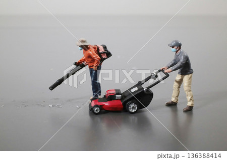 Miniature Groundskeepers Operate Leaf Blower And Lawn Mower 136388414