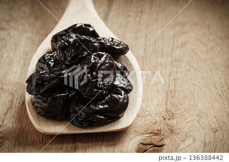 dried plums prunes on wooden spoon dried plums prunes on wooden spoon 136388442