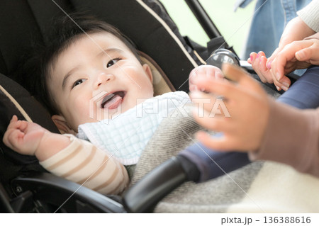 ベビーカーに乗った赤ちゃんをあやす 笑顔の赤ちゃん ベビーカーに乗った赤ちゃんをあやす 笑顔の赤ちゃん 136388616