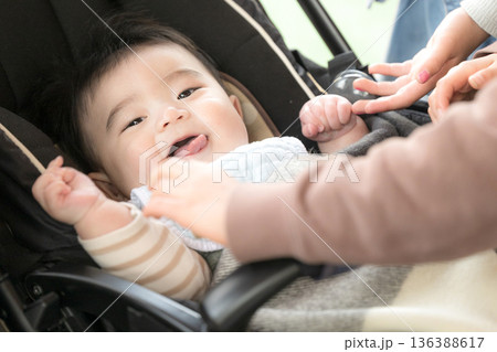 ベビーカーに乗った赤ちゃんをあやす　笑顔の赤ちゃん 136388617