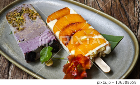 Grilled peach ice cream topped with butter, honey, yogurt, and granola, served on a stick. Grilled peach ice cream topped with butter, honey, yogurt, and granola, served on a stick. 136388659