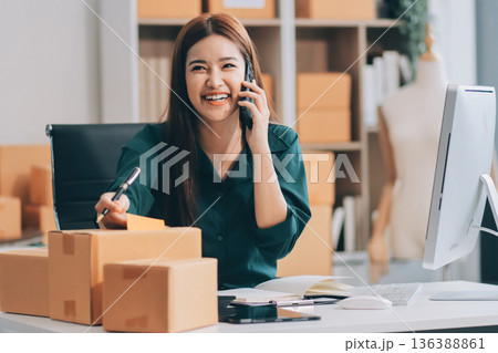 Starting small businesses SME owners female entrepreneurs check online orders to prepare to pack the boxes, sell to customers, sme business ideas online. Starting small businesses SME owners female entrepreneurs check online orders to prepare to pack the boxes, sell to customers, sme business ideas online. 136388861