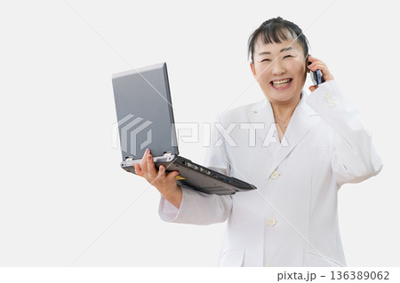 パソコンとスマホと若い女性 136389062