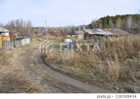 A winding street with a dirt road in the village of Fakel Revolyutsii in Siberia, Russia A winding street with a dirt road in the village of Fakel Revolyutsii in Siberia, Russia 136389434
