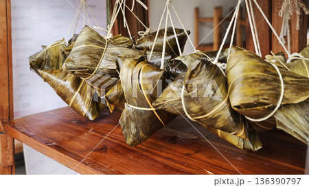 Zongzi, an ancient Chinese traditional dish wrapped in fragrant leaves, crafted with fine ingredients and cherished in cultural festival rituals. 136390797